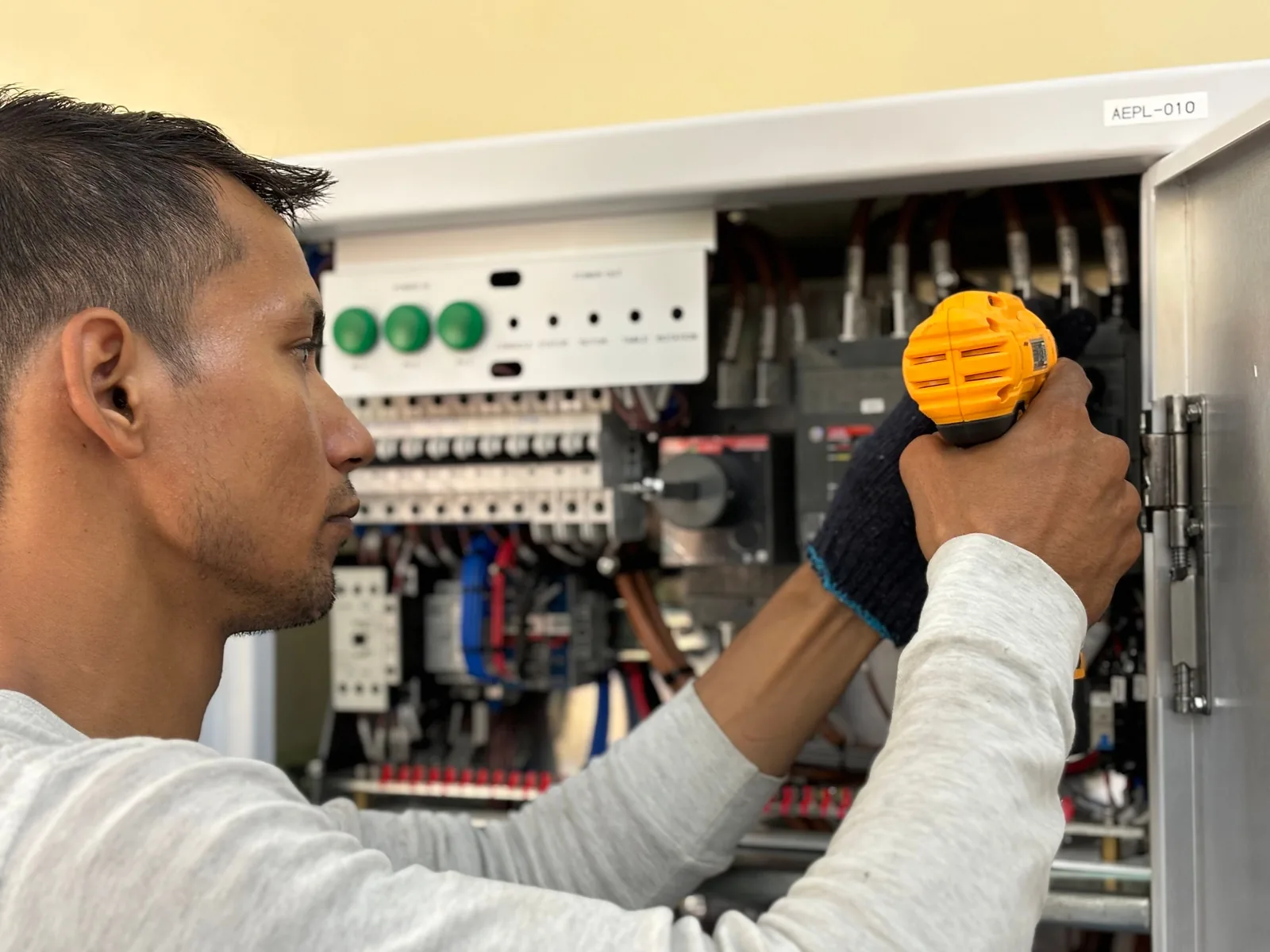An electrician working on a commercial control panel, for subpanel installation in Edmonton